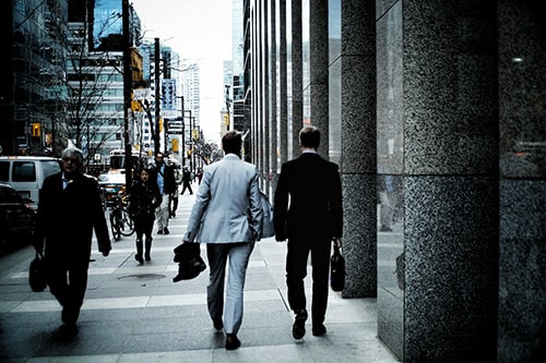 Dois advogados andando em calçada de avenida famosa