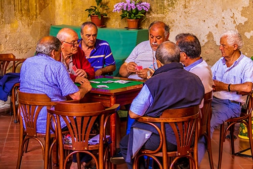 Sete aposentados jogando baralho