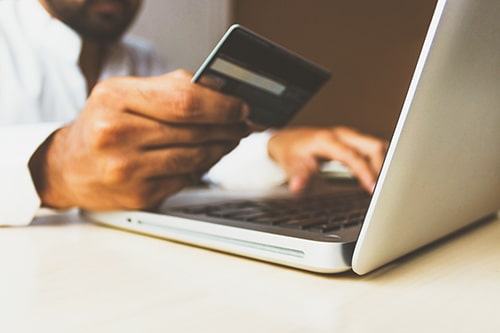Homem fazendo compra online com seu cartão de crédito