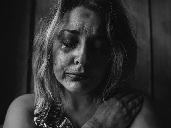 Mulher desconsolável chorando em foto em preto e branco