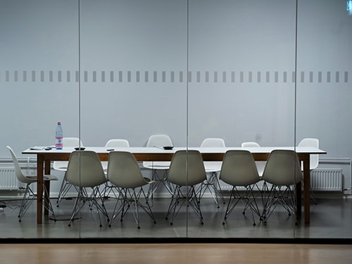 Sala de reunião com uma mesa e 12 cadeiras vazias