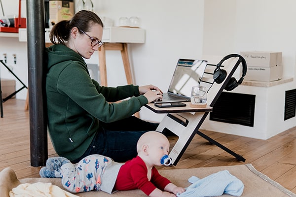 Mãe trabalhando em home office ao lado de seu bebê